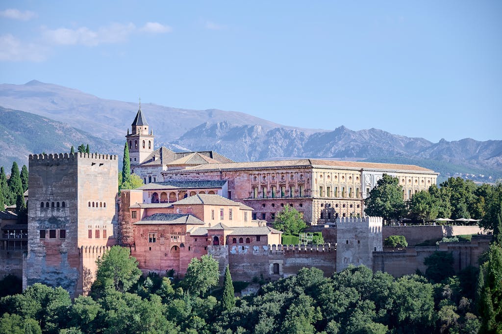 Stunning view of the Alhambra and Sierra Nevada mountains in Granada, Spain, showcasing iconic Andalusian architecture.